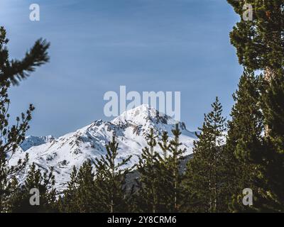 Una splendida vista sulla cima innevata del Serre Chevalier di Brianza, su un cielo azzurro e limpido. L'aspro paesaggio montano ne mette in mostra la bellezza Foto Stock