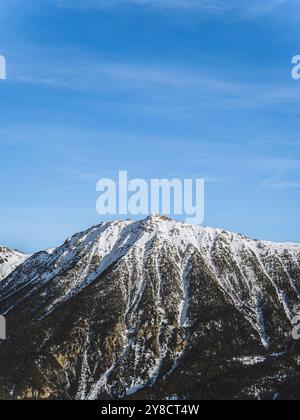 Una splendida vista sulla cima innevata del Serre Chevalier di Brianza, su un cielo azzurro e limpido. L'aspro paesaggio montano ne mette in mostra la bellezza Foto Stock