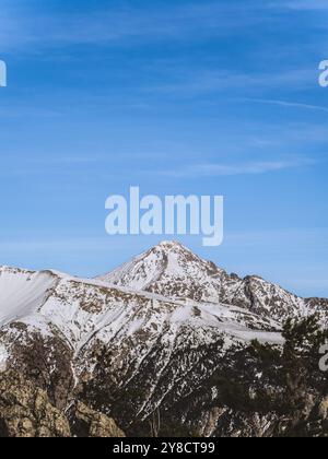 Una splendida vista sulla cima innevata del Serre Chevalier di Brianza, su un cielo azzurro e limpido. L'aspro paesaggio montano ne mette in mostra la bellezza Foto Stock