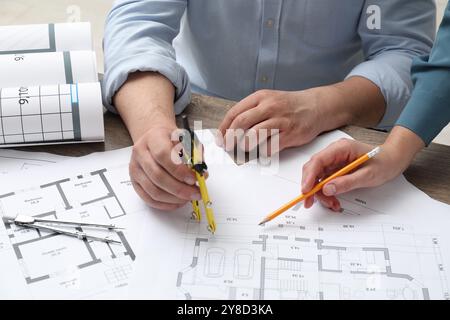 Architetti che lavorano con il progetto, primo piano. Disegni tecnici diversi su un tavolo di legno Foto Stock