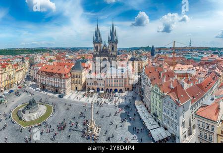 Vista aerea dei turisti che si godono una giornata di sole nella piazza della città vecchia di Praga con la chiesa di Tyn che torreggia sul paesaggio urbano, Repubblica Ceca Foto Stock