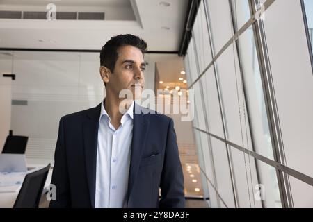 Il direttore dell'azienda è un uomo con una giacca formale che posa in ufficio Foto Stock