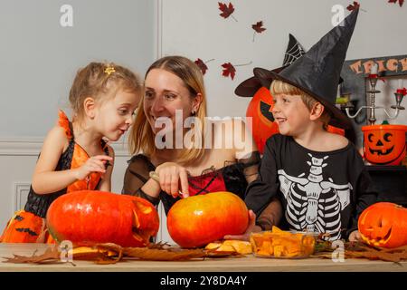 Famiglia che ama le attività di Halloween, intagliando le zucche insieme Foto Stock