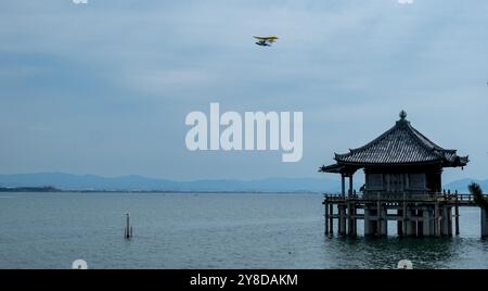 Sala del tempio di Ukimido che galleggia sul lago Biwa, tempio buddista Mangetsuji nella città di Otsu, prefettura di Shiga, Giappone. Un aereo sorvola l'edificio Foto Stock