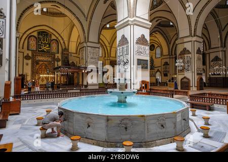 Bursa, Turchia - 7 settembre 2024: Un uomo si lava nella fontana della grande Moschea di Bursa in Turchia. Foto Stock