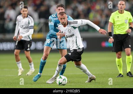 Sergi Altimira del Real Betis Balompie (L) e Tomas Pekhart di Legia Warszawa (R) visti in azione durante la partita di UEFA Conference League 2024/2025 tra Legia Warszawa - Real Betis Balompie al Marshall Jozef Pilsudskis Municipal Stadium di Legia Varsavia. Punteggio finale; Legia Warszawa 1:0 Real Betis Balompie. Foto Stock