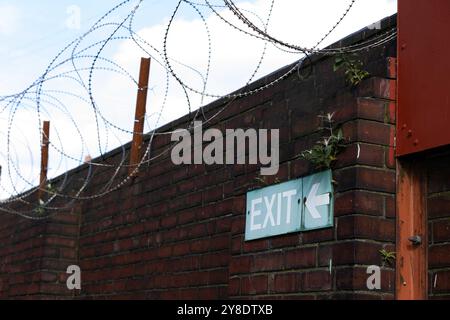 Rotherham, Regno Unito. 4 ottobre 2024. Un cartello di uscita sotto il filo spinato come Millmoor Stadium, l'ex sede del Rotherham United FC, viene riaperto al pubblico. Il Rotherham United ha giocato l'ultima volta al Millmoor 16 anni fa, ma ora il Ghost Ground sta tornando in vita con il campo che viene messo a disposizione delle squadre locali. (Foto di Ben Booth/SOPA Images/Sipa USA) credito: SIPA USA/Alamy Live News Foto Stock