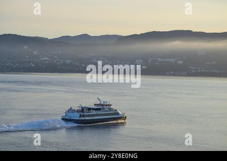 Traghetto che attraversa il Mare del Nord alla luce dell'alba, con Bergen sullo sfondo, Bergen, Vestland, Norvegia, Europa Foto Stock