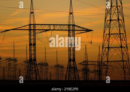 Alte torri di tensione al tramonto Foto Stock