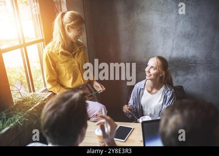 Gruppo di colleghi aventi riuniti nella sala riunioni mentre si lavora su una presentazione di grandi dimensioni e la preparazione della loro strategia commerciale. Progettisti creativi cercando br Foto Stock