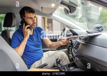 Uomo caucasico maturo che parla con il cellulare seduto all'interno di un furgone Foto Stock