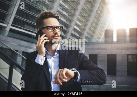 Bell'uomo d'affari di successo in elegante abito all'aperto che cammina per strada in città Foto Stock