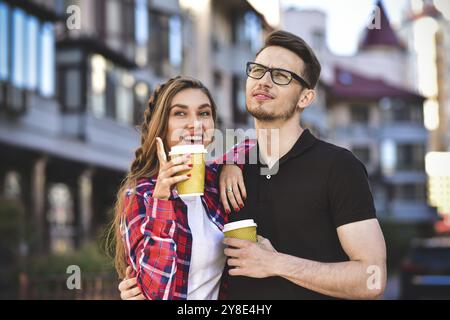 Ritratto di coppia felice a camminare per strada con caffè Foto Stock