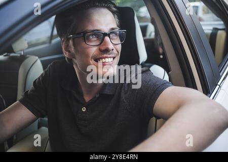 Buon viaggio. Immagine di un giovane bel ragazzo seduto in macchina Foto Stock