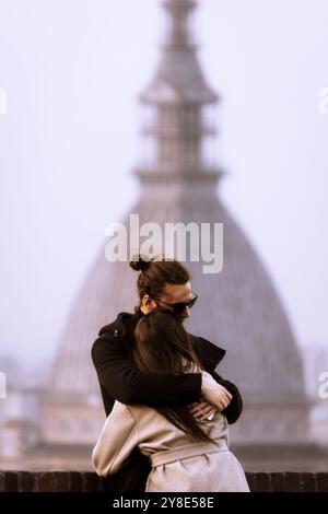 Un paio di abbracci di fronte alla Mole Antonelliana, il punto di riferimento di Torino, Piemonte, Italia. Foto Stock