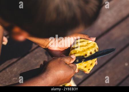 Uomo che produce pezzi unici di ananas. Precisione e creatività. Foto Stock