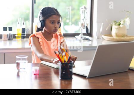 Ragazza birazziale impegnata nell'apprendimento online a casa Foto Stock