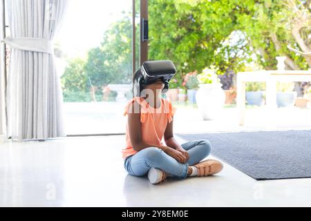 La ragazza birazziale esplora la realtà virtuale a casa Foto Stock