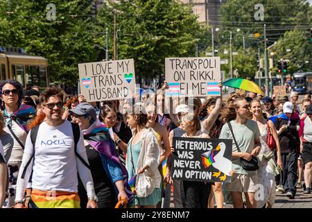 Persone con cartelli fatti a mano alla parata Helsinki Pride 2024 su Mannerheimintie a Helsinki, Finlandia Foto Stock