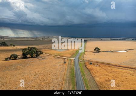 Vista aerea della pioggia che cade da un buio fronte temporale sopra i terreni agricoli di Campbelltown nel Victoria centrale, Australia Foto Stock