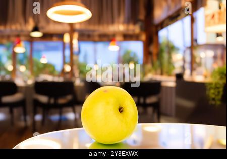 Una mela gialla sul tavolo nel ristorante. Foto Stock