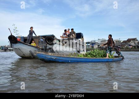 CAI RANG, VIETNAM - 17 FEBBRAIO 2013: Persone che viaggiano e lavorano con le loro barche di legno nel delta del Mekong dove il trasporto è possibile solo su b Foto Stock