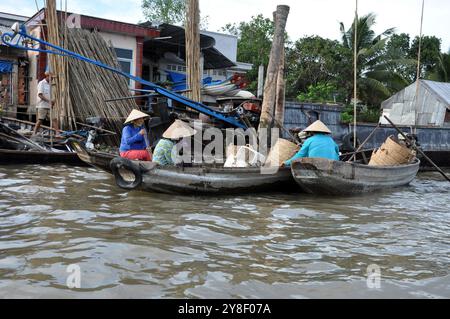 CAI RANG, VIETNAM - 17 FEBBRAIO 2013: Persone che viaggiano e lavorano con le loro barche di legno nel delta del Mekong dove il trasporto è possibile solo su b Foto Stock