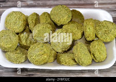 Falafel prefritto surgelato, polpette di falafel prefritte tradizionali egiziane, hamburger verde, a base di ceci macinati e fagioli, da friggere in un'ocia profonda Foto Stock