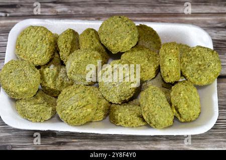 Falafel prefritto surgelato, polpette di falafel prefritte tradizionali egiziane, hamburger verde, a base di ceci macinati e fagioli, da friggere in un'ocia profonda Foto Stock