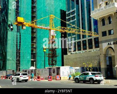 Medina, Arabia Saudita, giugno 27 2024: Un sito di costruzione di un nuovo grattacielo alto nella città di Madinah con una torre di gru Liebherr in costruzione Foto Stock