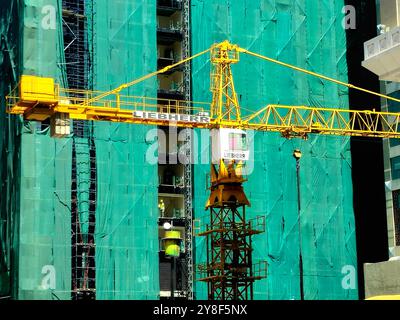 Medina, Arabia Saudita, giugno 27 2024: Un sito di costruzione di un nuovo grattacielo alto nella città di Madinah con una torre di gru Liebherr in costruzione Foto Stock