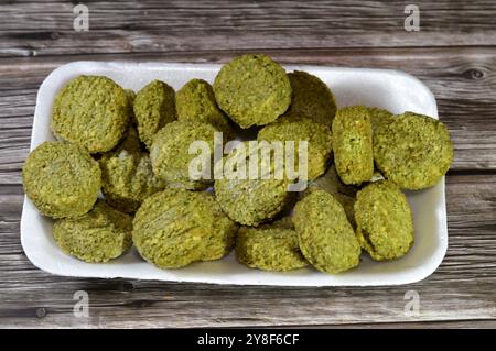 Falafel prefritto surgelato, polpette di falafel prefritte tradizionali egiziane, hamburger verde, a base di ceci macinati e fagioli, da friggere in un'ocia profonda Foto Stock
