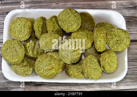 Falafel prefritto surgelato, polpette di falafel prefritte tradizionali egiziane, hamburger verde, a base di ceci macinati e fagioli, da friggere in un'ocia profonda Foto Stock