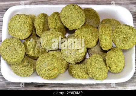 Falafel prefritto surgelato, polpette di falafel prefritte tradizionali egiziane, hamburger verde, a base di ceci macinati e fagioli, da friggere in un'ocia profonda Foto Stock