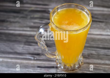 Frantumare la bevanda alla pesca con veri pezzi di frutta, refrigerata e fredda, succo naturale rinfrescante, miscela di succo morbido e vera frutta a pezzi con V. Foto Stock