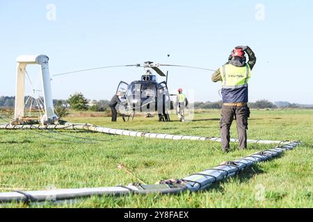 Geophysikalische Messungen mit Hubschrauber. Ein Mitarbeiter der firma SkyTeam weißt den Hubschrauber ein. DAS Niedersächsische Landesamt für Bergbau, energie und Geologie tätigt derzeit unter anderem in Ostfriesland geophysikalische Messungen mit Blick auf das Grundwasser, die von einem Hubschrauber unterstützt werden. Dabei wird vom 4. bis voraussichtlich zum 16. Oktober eine große antenne in etwa 30 Metern Höhe über die Geländeoberfläche geschleppt. Durch das sogenannte SkyTEM-Verfahren solle bei Flügen rund um Emden, Leer, Aurich, Cloppenburg und auch im Ammerland bei Oldenburg mit der Ant Foto Stock