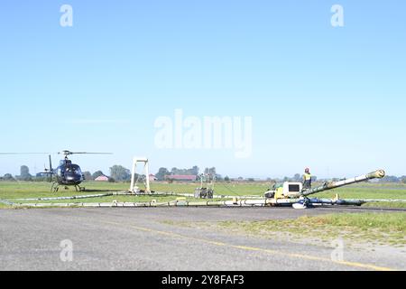 Geophysikalische Messungen mit Hubschrauber. Ein Mitarbeiter der firma SkyTeam weißt den Hubschrauber ein. DAS Niedersächsische Landesamt für Bergbau, energie und Geologie tätigt derzeit unter anderem in Ostfriesland geophysikalische Messungen mit Blick auf das Grundwasser, die von einem Hubschrauber unterstützt werden. Dabei wird vom 4. bis voraussichtlich zum 16. Oktober eine große antenne in etwa 30 Metern Höhe über die Geländeoberfläche geschleppt. Durch das sogenannte SkyTEM-Verfahren solle bei Flügen rund um Emden, Leer, Aurich, Cloppenburg und auch im Ammerland bei Oldenburg mit der Ant Foto Stock