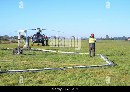 Geophysikalische Messungen mit Hubschrauber. Ein Mitarbeiter der firma SkyTeam weißt den Hubschrauber ein. DAS Niedersächsische Landesamt für Bergbau, energie und Geologie tätigt derzeit unter anderem in Ostfriesland geophysikalische Messungen mit Blick auf das Grundwasser, die von einem Hubschrauber unterstützt werden. Dabei wird vom 4. bis voraussichtlich zum 16. Oktober eine große antenne in etwa 30 Metern Höhe über die Geländeoberfläche geschleppt. Durch das sogenannte SkyTEM-Verfahren solle bei Flügen rund um Emden, Leer, Aurich, Cloppenburg und auch im Ammerland bei Oldenburg mit der Ant Foto Stock