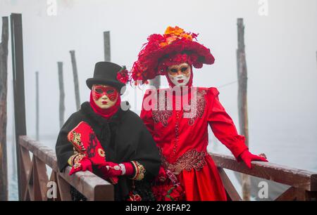 Una coppia mascherata per il carnevale in Piazza San Marco sul molo della Gondola Foto Stock