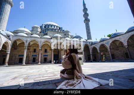 Turkiye. Istanbul. Una donna che indossa un abito tradizionale ammira la Moschea di Solimano o la Moschea di Solimano Foto Stock