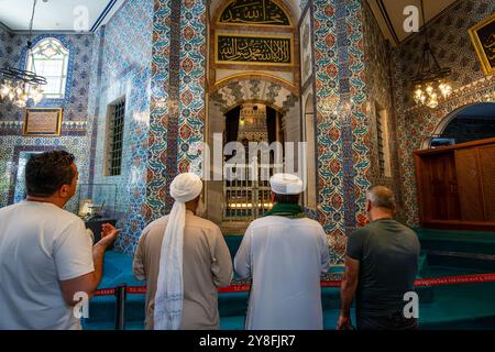 Turkiye. Istanbul. Quattro uomini in preghiera davanti alla tomba del sultano Eyup a Istanbul, situata all'interno della moschea del sultano Eyup. Foto Stock