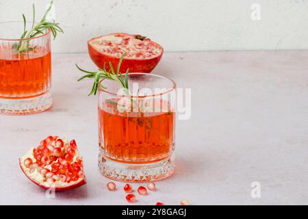 Una bevanda natalizia a base di succo di melograno e rosmarino. Cocktail natalizio per il giorno del Ringraziamento, Natale o Capodanno. Foto Stock