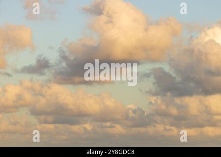 Questa immagine mostra un cielo pieno di nuvole durante il tramonto, date le tonalità calde vicino all'orizzonte. Foto Stock