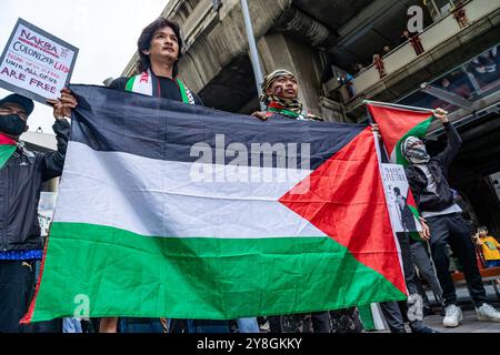 Bangkok, Thailandia. 5 ottobre 2024. I manifestanti marciano con una bandiera durante una marcia pro-Palestina. Una marcia a favore della Palestina è stata organizzata dal gruppo di campagna locale in solidarietà con la Palestina, Thailandia. Credito: SOPA Images Limited/Alamy Live News Foto Stock