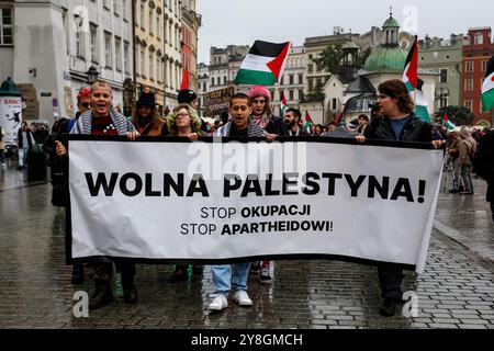 I palestinesi, i libanesi e i loro sostenitori protestano a sostegno della Palestina e contro le azioni di guerra israeliane nella Striscia di Gaza, in Cisgiordania e in Libano nella piazza principale della città vecchia di Cracovia. Si vedono bandiere della Palestina e cartelli pro-Palestina. Foto Stock