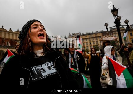 I palestinesi, i libanesi e i loro sostenitori protestano a sostegno della Palestina e contro le azioni di guerra israeliane nella Striscia di Gaza, in Cisgiordania e in Libano nella piazza principale della città vecchia di Cracovia. Si vedono bandiere della Palestina e cartelli pro-Palestina. Foto Stock