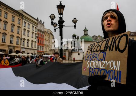 Un uomo partecipa a una protesta a sostegno della Palestina e contro le azioni di guerra israeliane nella Striscia di Gaza, in Cisgiordania e in Libano nella piazza principale della città vecchia di Cracovia. Si vedono bandiere della Palestina e cartelli pro-Palestina. Foto Stock