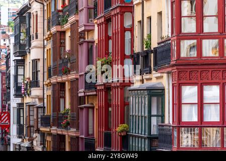 Tipica facciata di edifici residenziali con balconi e finestre a bovindo nel centro di Bilbao, regione autonoma dei Paesi baschi in Spagna Foto Stock