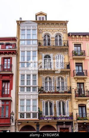 Tipica facciata di edifici residenziali con balconi e finestre a bovindo nel centro di Bilbao, regione autonoma dei Paesi baschi in Spagna Foto Stock