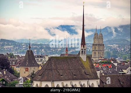 Torri dell'orologio della chiesa nello skyline di Zurigo, mattinata nuvolosa Foto Stock